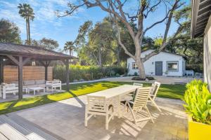 een patio met een houten tafel en stoelen bij Modern home near colleges in Claremont