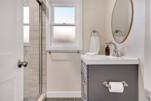 een badkamer met douche, wastafel en spiegel bij Modern home near colleges in Claremont +25 foto's