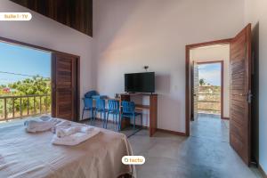 マセイオにあるApto 100m da praia no Pontal de Maceió por Tactuのベッドとテレビとバルコニーのある寝室