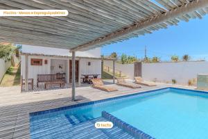 a villa with a swimming pool and a wooden deck at Apto 100m da praia no Pontal de Maceió por Tactu in Fortim