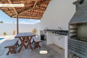 a kitchen with a picnic table and a stove at Apto 100m da praia no Pontal de Maceió por Tactu in Fortim