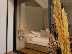 a reflection of a bedroom with a bed in a mirror at Cozy Appart central à terrasse in Casablanca