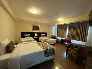 Habitación de hotel con 2 camas y mesa en El Tambo 1, en Lima