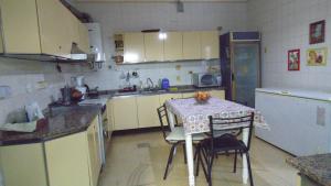 eine kleine Küche mit einem Tisch, einem Tisch und Stühlen in der Unterkunft Albergue Casa Elena in San Miguel de Tucumán