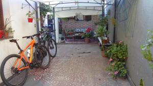 una bicicletta arancione parcheggiata accanto a un edificio con piante di Albergue Casa Elena a San Miguel de Tucumán