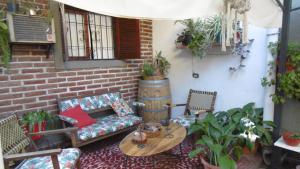 een patio met een bank en een tafel en stoelen bij Albergue Casa Elena in San Miguel de Tucumán