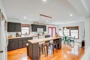 una cocina con armarios negros y una mesa con sillas en Secluded Catskill Home with Hiking Trails On-Site!, en Catskill