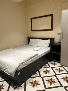 ein großes Bett mit schwarzem Rahmen und weißer Bettwäsche in der Unterkunft OYO Flagship The Thangal Hotel in Imphal