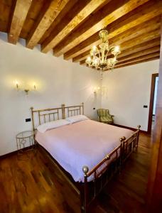 1 dormitorio con cama y lámpara de araña en Tiepolo 3, en Venecia