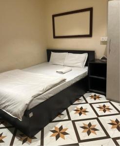 um quarto com uma cama com uma moldura preta em OYO Flagship The Thangal Hotel em Imphal
