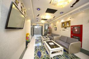 a living room with a tv and a couch and a tv at Hafez Hotel Apartments in Dubai