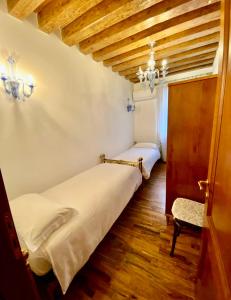 Un dormitorio con 2 camas y una silla. en Tiepolo 3, en Venecia