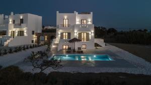 a large white house with a swimming pool in front of it at Nymphée Luxury Villas in Agia Anna Naxos