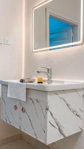 a white bathroom with a sink and a mirror at Peacefull night in Al Madinah