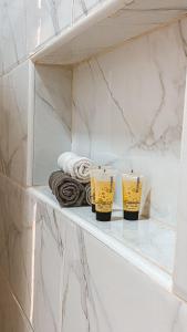 two cups sitting on a shelf in a bathroom at Peacefull night in Al Madinah +16 photos