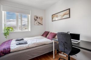 um quarto com uma cama e uma secretária com um computador em Budget studio by the city canal em Trondheim