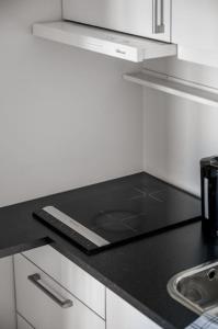 uma bancada preta numa cozinha branca em Budget studio by the city canal em Trondheim