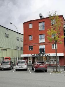 a parking lot with cars parked in front of a building at Budget studio by the city canal in Trondheim