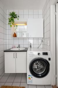 a kitchen with a washing machine and a sink at Budget studio by the city canal in Trondheim