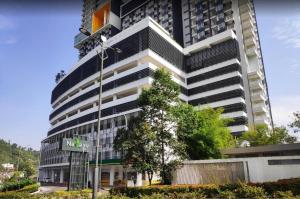 un edificio alto con un letrero de la calle delante de él en Nadayu Studio 舒适环境民宿大阳台适合举办生日会, en Kuala Lumpur