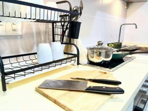 una encimera con tabla de cortar y utensilios de cocina en Nadayu Studio 舒适环境民宿大阳台适合举办生日会, en Kuala Lumpur