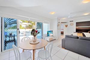 a living room with a couch and a table and chairs at Ohana Vibe Bargara in Bargara