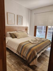 1 cama grande en un dormitorio con ventana en R&R Vibes en Villa La Angostura