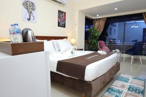 カイロにあるCairo City Center Dreamers Hotel & Suitesの大きなベッドとテーブルが備わるホテルルームです。