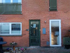 - un bâtiment en briques rouges avec une porte et une fenêtre dans l'établissement Private room near Copenhagen, à Ishøj