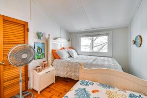 Schlafzimmer mit einem Bett, einem Ventilator und einem Fenster in der Unterkunft Tranquil Auburn Lakehouse with Sunroom and Game Room! in Auburn