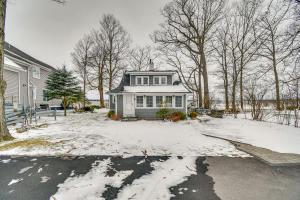 una casa blanca con nieve en el suelo en Tranquil Auburn Lakehouse with Sunroom and Game Room!, en Auburn