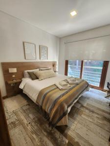 1 dormitorio con cama grande y ventana grande en R&R Vibes en Villa La Angostura