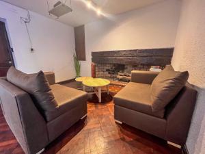 sala de estar con 2 sofás y chimenea en Casa Montaña en Salta