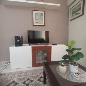 a living room with a flat screen tv and a table at amplia y cómoda casa 