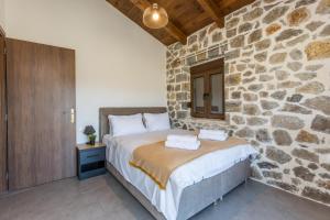 um quarto com paredes de pedra e uma cama num quarto em Raise Polydrosos Alpine Escape em Polydrossos