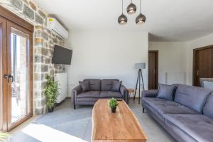 a living room with two couches and a wooden table at Raise Polydrosos Alpine Escape in Polydrossos