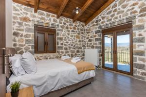 a bedroom with a bed and a stone wall at Raise Polydrosos Alpine Escape in Polydrossos