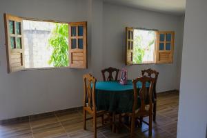 uma mesa e cadeiras num quarto com janelas em Cabañas en San Antero Bambumar2 em San Antero