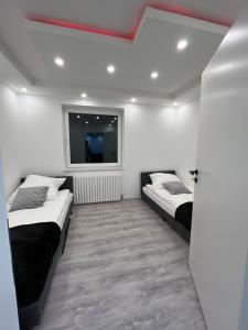 um quarto com duas camas e uma televisão na parede em Wohnung am Norderstedt Stadtpark em Norderstedt