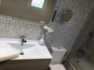 a bathroom with a sink and a toilet and a mirror at Veuràs el Mar - Almadrava Beach House in Roses