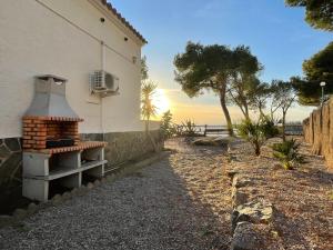 un edificio con una panchina accanto a un albero di Veuràs el Mar - Almadrava Beach House a Roses