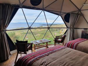 een kamer met 2 bedden en een tafel in een tent bij Titikaka Sky View in Juliaca