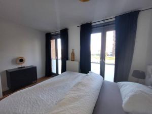 een slaapkamer met 2 witte bedden en een raam bij Alex Place in Utrecht