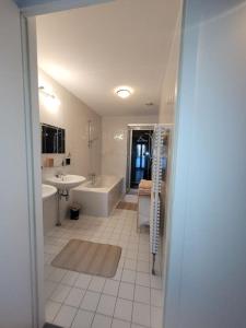 een witte badkamer met een bad en een wastafel bij Alex Place in Utrecht