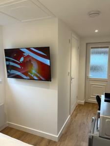 a room with a television on a wall at Novanik Studio Apartment in Milton Keynes