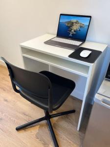 a desk with a laptop computer and a chair at Novanik Studio Apartment in Milton Keynes