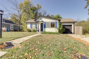 a house with a yard with a driveway at Chic Joplin Cottage with Patio Less Than 3 Mi to Town! in Joplin