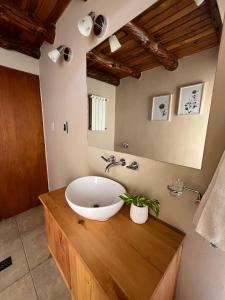 y baño con lavabo en un mostrador de madera. en Cabañas Temistocles en Esquel