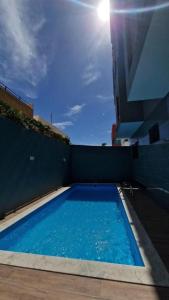 a large blue swimming pool on the side of a building at Aparthouse EdHel T2 in Praia