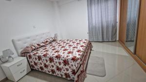 Schlafzimmer mit einem Bett mit einer roten und weißen Decke in der Unterkunft Aparthouse EdHel T2 in Praia